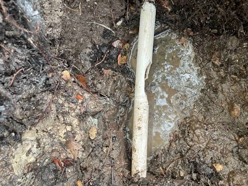 Muddy buried pipe leak before repair